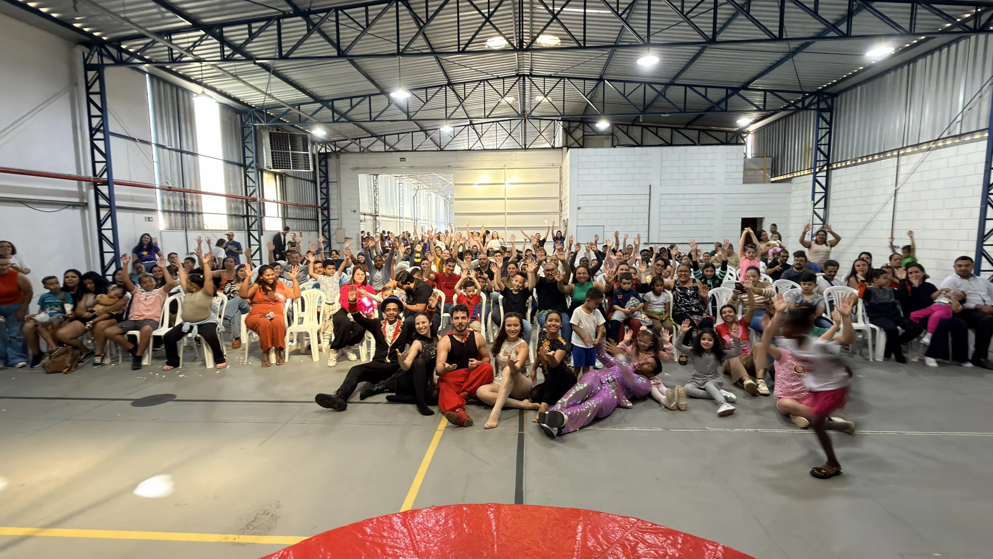 Apresentação temática de circo com famílias, crianças e equipe reunida